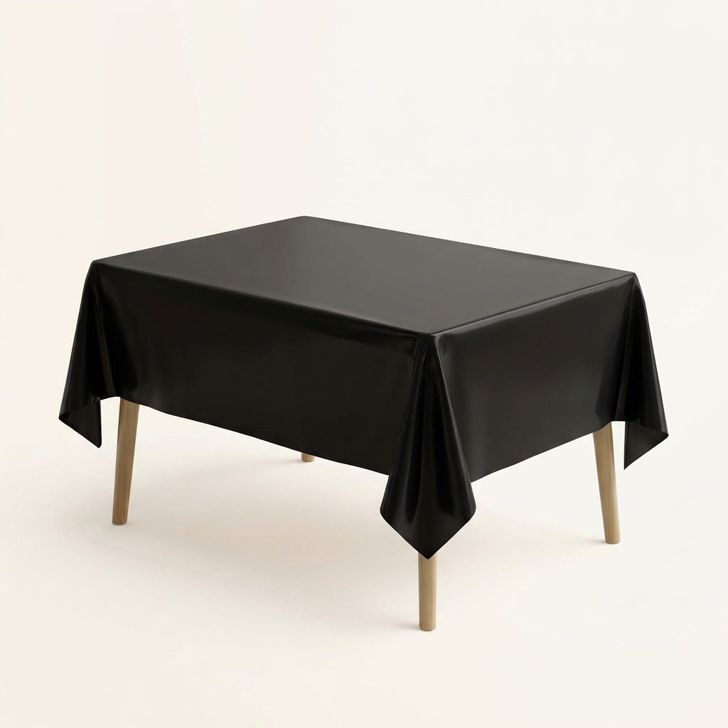 Black plastic party table cover on a rectangular table against a plain background