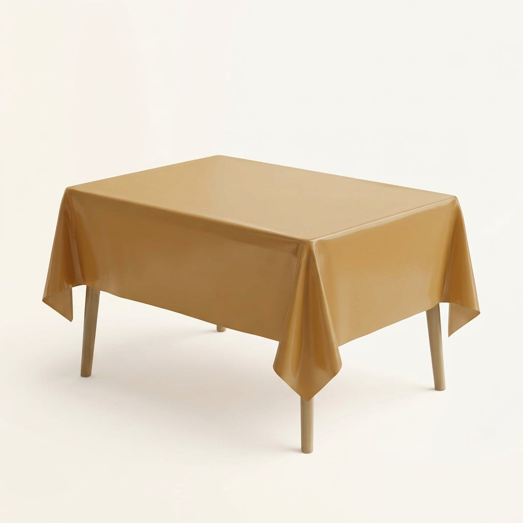 Golden plastic party table cover on a rectangular table against a plain background
